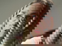 A close-up of Denise Huskins crying and rubbing her eye.