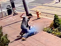 Attacker is beating a pro-life activist on the ground.