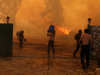 KRIONERI, ATHENS - JULY 26: Smoke and flame rise as firefighting teams respond from the ai