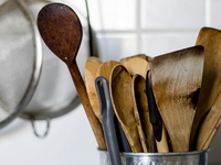 Old wooden kitchen utensils in a metal bowl