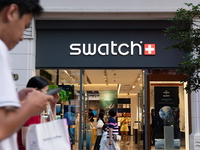 Pedestrians pass by the Swatch watch store on Nanjing Road Pedestrian Street in Shanghai,